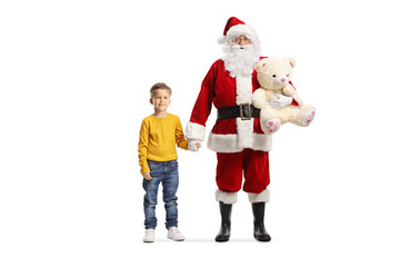 Santa Claus holding hands with a boy and carrying a teddy bear