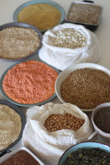 Bowls and bags full of various healthy grains and legumes. Selective focus.