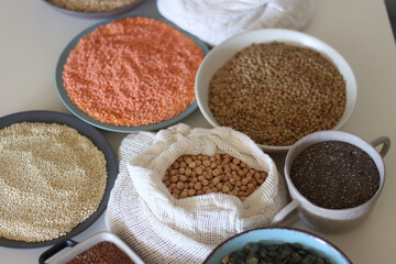 Bowls and bags full of various healthy grains and legumes. Selective focus.