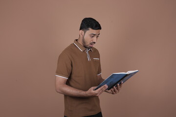 Focused young man reading large book – concept of learning, discovery, concentration, curiosity, and intellectual engagement