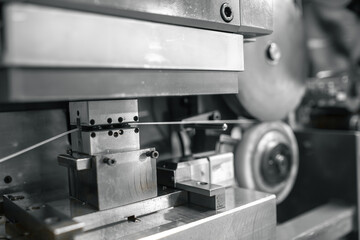 Close-up reveals intricate machinery meticulously testing a wire's tensile strength.