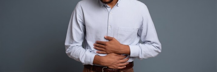 Young hispanic male experiencing stomach pain in casual attire
