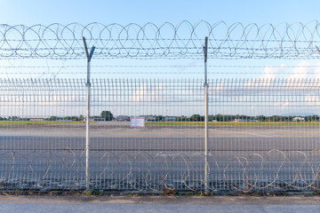 Barbed wire fence or wall located around forbidden area or zone of airfield at the airport