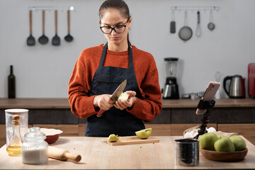 Woman cutting apples with big knife for apple pie. autumn bakery. sweets. Vegan dessert from fruits.