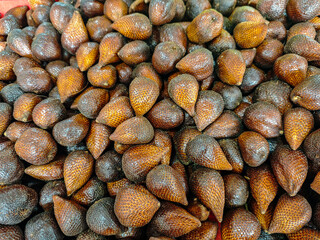 A close-up showcases a bounty of salak fruit, their textured, brown scales catching the light, creating a warm, inviting visual, ideal for illustrating tropical harvests and culinary inspirations.