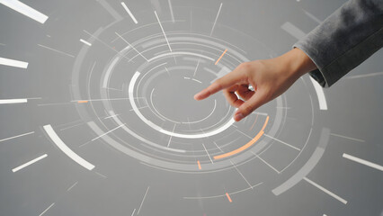 Hand pointing at a circular holographic display with glowing orange accents, future concept.