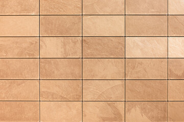 Warm beige stone tiles arranged in a neat grid, with visible grout lines and subtle natural textures, perfect for backgrounds in interior design, architecture, renovation, or flooring projects.