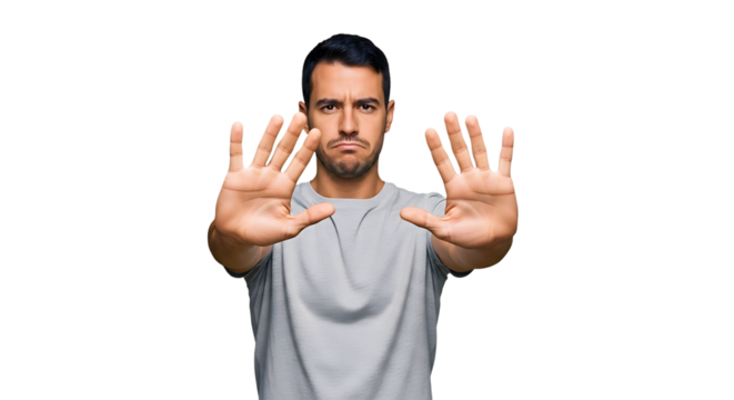 Serious man showing his hands and signaling stop isolated on transparent background he is wearing a gray tshirt and has a determined expression