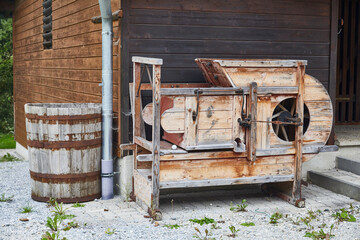 Antike Dreschmaschine an einem Bauernhaus in den österreichischen Alpen.