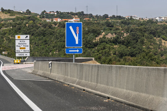 Road signs on a Portuguese highway (N356) indicating an exit in 1400m for Batalha, Rego Fetal, and Alqueid&atilde;o da Serra. Merge lane sign visible.