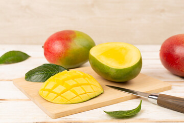Fresh ripe mango with leaves on wooden table