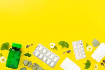 Herbs and flowers with medicines on color background, top view