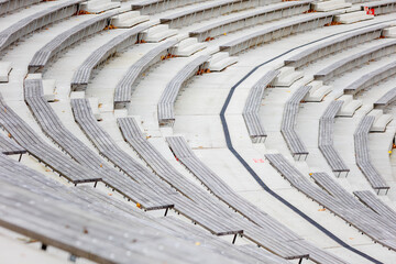 Zbliżenie na betonową strukturę siedzisk amfiteatru ukazujące powtarzalny rytm geometrycznych form i surową estetykę architektury. Kompozycja podkreśla teksturę, linię i minimalistyczny charakter prze