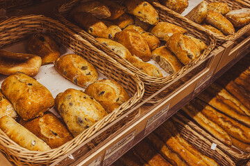 Freshly baked bread with raisins on a wooden stand in the bakery taken off the shelf in the supermarket.