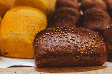 Freshly baked bread with raisins on a wooden stand in the bakery taken off the shelf in the supermarket.