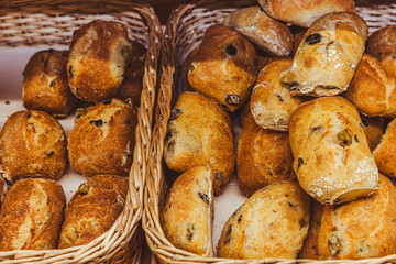 Freshly baked bread with raisins on a wooden stand in the bakery taken off the shelf in the supermarket.
