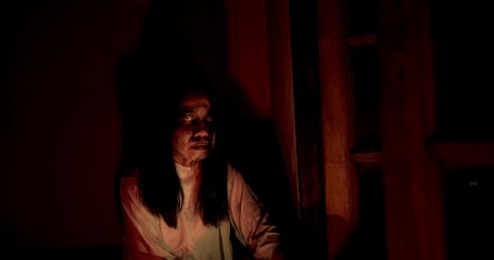 Horror scene of a person Mysterious Figure Asian ghost woman creepy have long hair looking to camera in Nighttime Scene with Eerie Red Light, festival Halloween