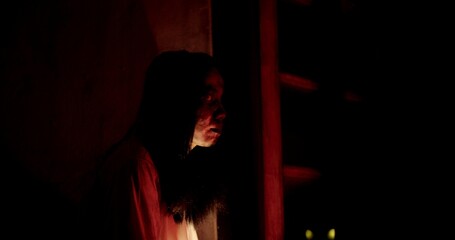 Horror scene of a person Mysterious Figure Asian ghost woman creepy have long hair looking to camera in Nighttime Scene with Eerie Red Light, festival Halloween