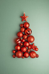 Green and Gold Christmas Ornaments Hanging on Pine Branches over Muted Green Background