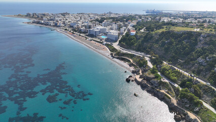 Fototapeta premium Aerial drone photo of beautiful beach with wonderful seaside promenade of Kato Petres featuring Cave Archangel Michael Panormitis, Rhodes island, Dodecanese, Greece