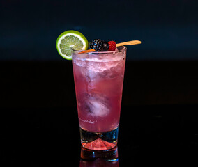 Vibrant Berry and Lime Cocktail with Crushed Ice in Highball Glass on Dark Background