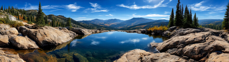 Obraz premium A beautiful mountain lake with a clear blue sky above. The lake is surrounded by rocks and trees, creating a serene and peaceful atmosphere
