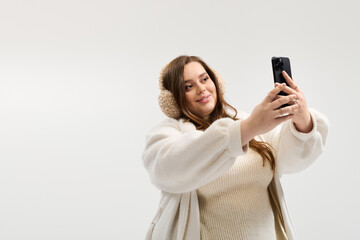 Young woman enjoys a cozy moment in a bright studio while taking a selfie
