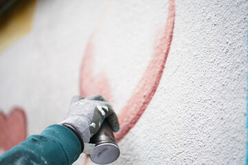 Painting graffiti on the wall. Close up. 