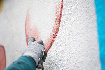 Painting graffiti on the wall. Close up. 