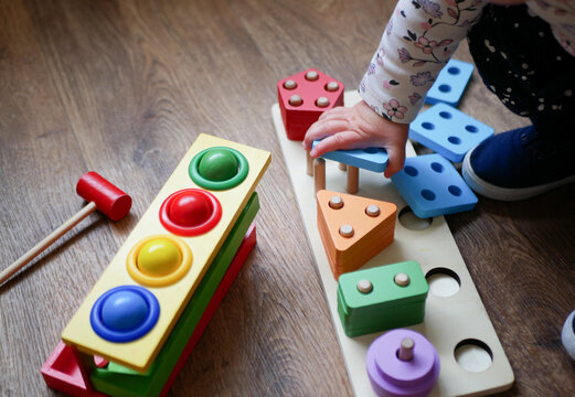Wooden sorter by colors and shapes for developing motor skills of a child's hands on the floor