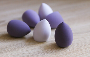 Makeup blender sponges in shape of eggs on table. Beauty concept