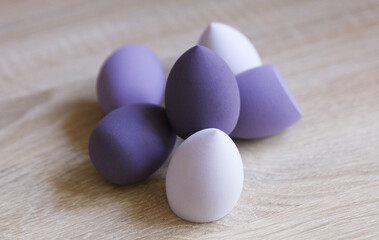 Makeup blender sponges in shape of eggs on table. Beauty concept