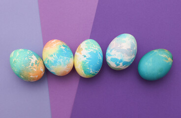 Colored Easter eggs on purple background