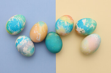 Colored Easter egg on pastel background. Top view