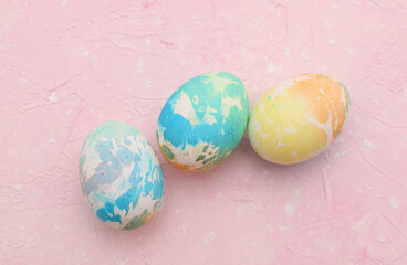 Colored Easter egg on pink pastel background. Top view