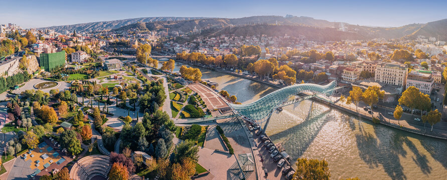 31 October 2025, Tbilisi, Georgia: Aerial view of Rike Park and the Bridge of Peace over the Mtkvari River during autumn