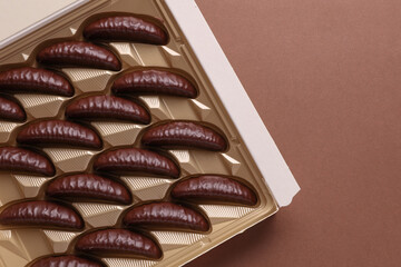Box of chocolate candies  on brown background. Top view