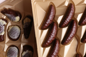 Different chocolate candies in form boxes close up