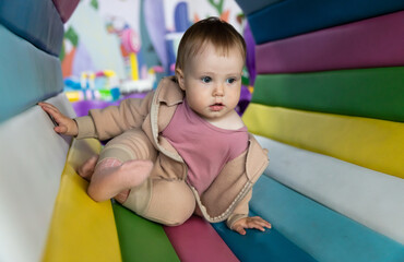 Little cute baby plays in a children's entertainment center