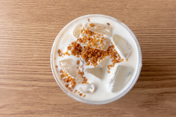 Iced coffee latte with creamy cold foam and caramel crumble. Close up view of Salted caramel milkshake with coffee