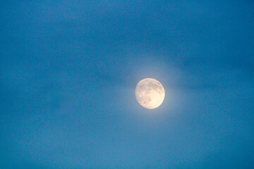Full Moon Shines Through Ethereal Blue Clouds