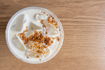 Iced coffee latte with creamy cold foam and caramel crumble. Close up view of Salted caramel milkshake with coffee