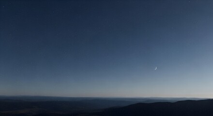 Crescent moon over the dark hills