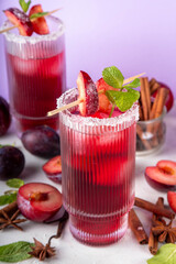 Sugar plum autumn winter sweet tasty drink. Alcohol or non-alcohol cocktail, mocktail with plum syrup, hard liqueur, spices, cinnamon and mint, copy space