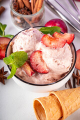 Winter flavor ice cream. Tasty Sugar plum  gelato in portioned bowl, with ice cream waffle cones, fresh and sugared plum fruits, copy space