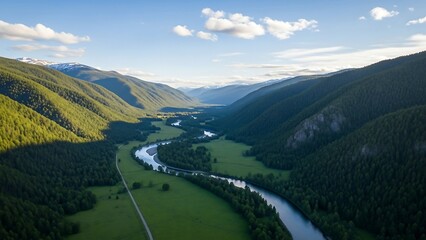 Aerial view of a winding river flowing through a lush green valley surrounded by mountains.