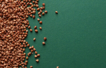 Buckwheat grains on a green background. Copy space