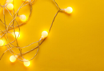 Obraz premium Glowing balls led garland on yellow background