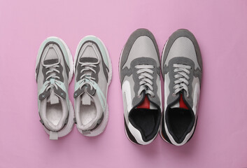 Male and female pair of sports shoes for running on pink background