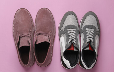 Fototapeta premium Sports sneakers and casual desert shoes on pink background. Top view